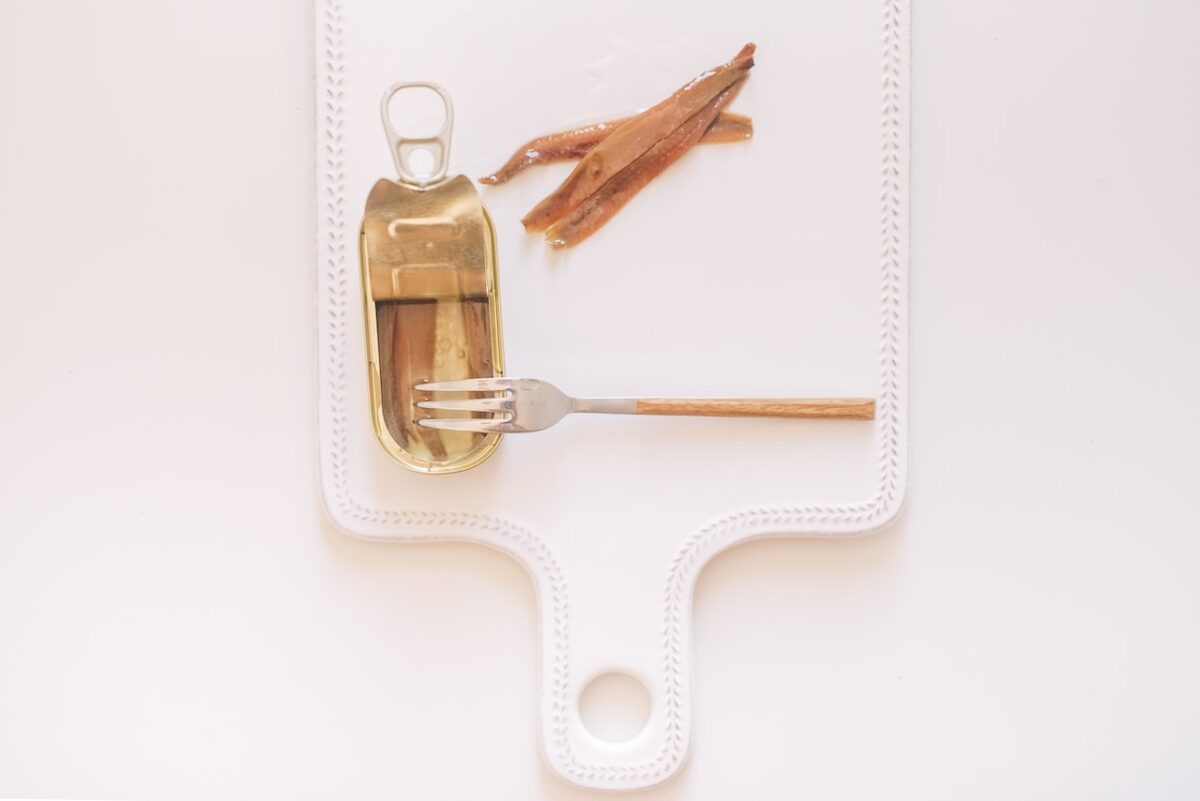 Far cuocere le alici o le acciughe sott'olio con aglio, olio, capperi e prezzemolo