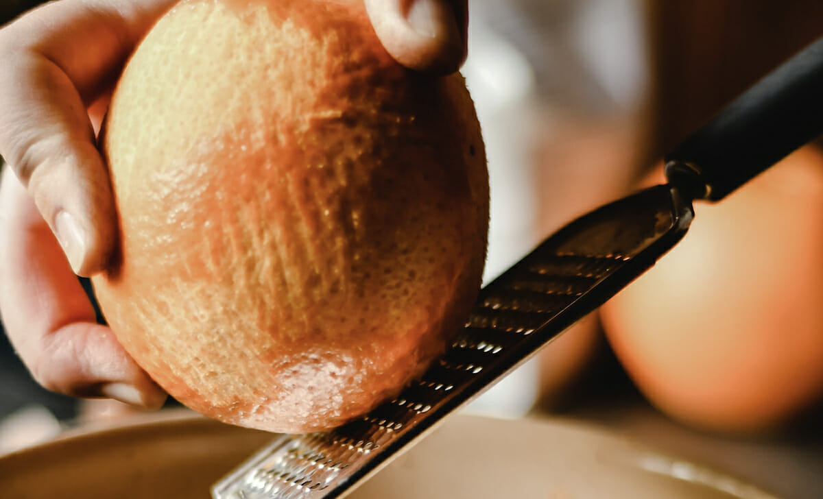 Iniziamo la preparazione dall'arancia grattugiandone la buccia e spremendone il succo