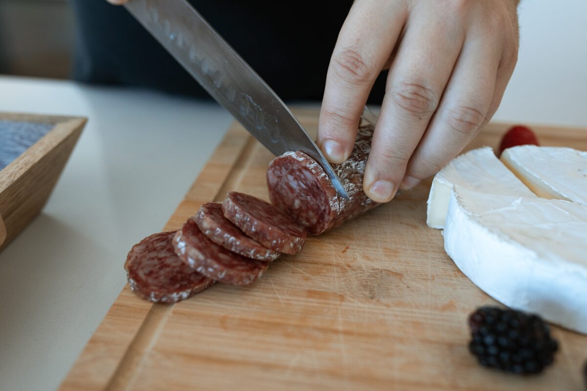 Tagliare il salame piccante e poi anche i formaggi